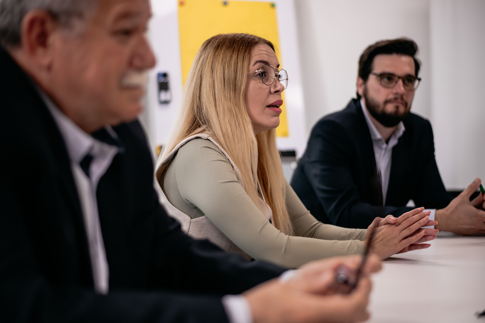 Un grupo de profesionales discute estrategias durante una reunión formal de negocios en un entorno de oficina moderno
