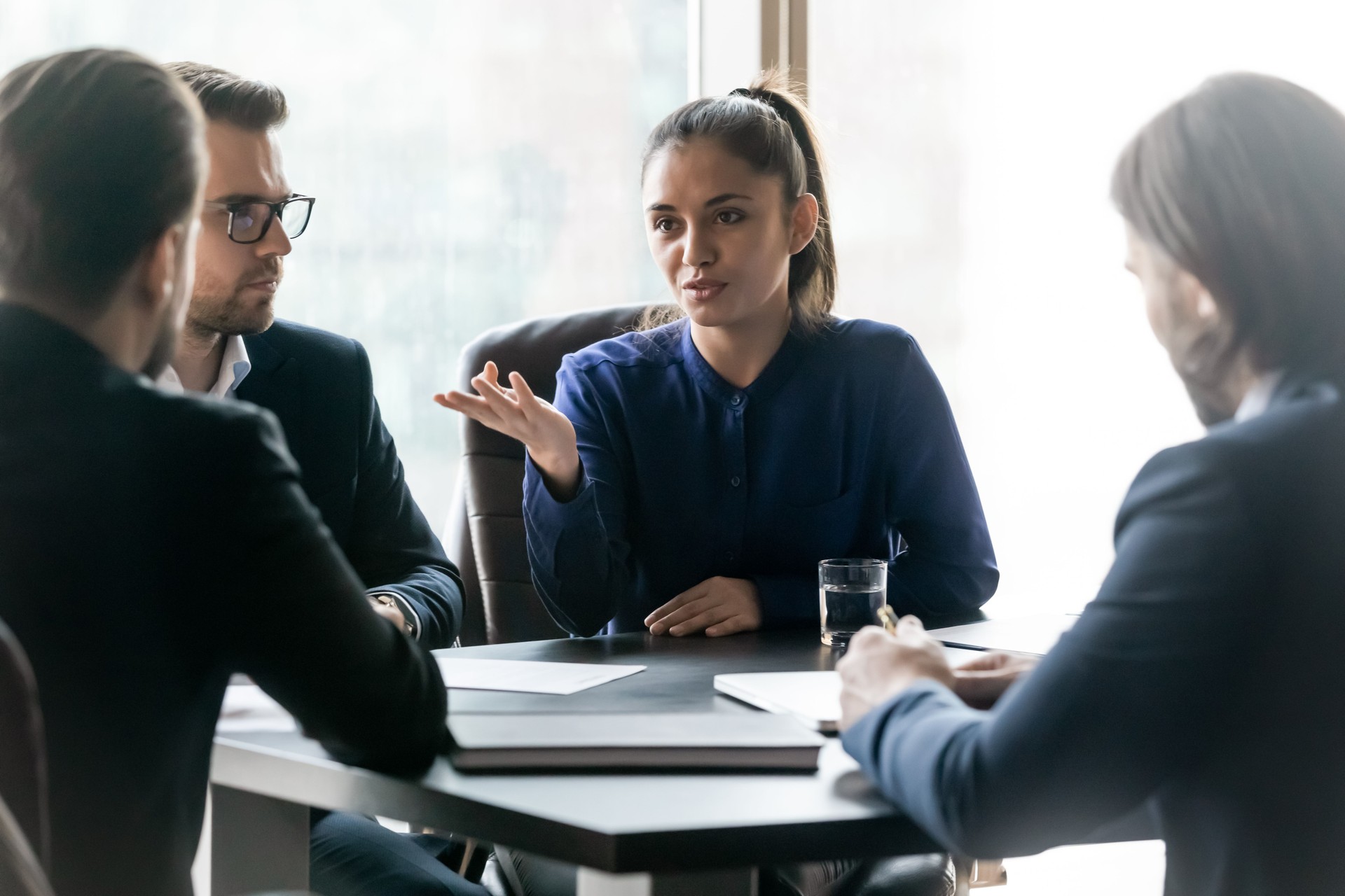 Atractiva mentora empresaria lleva a cabo el coaching en la sala de juntas en la reunión de la empresa.